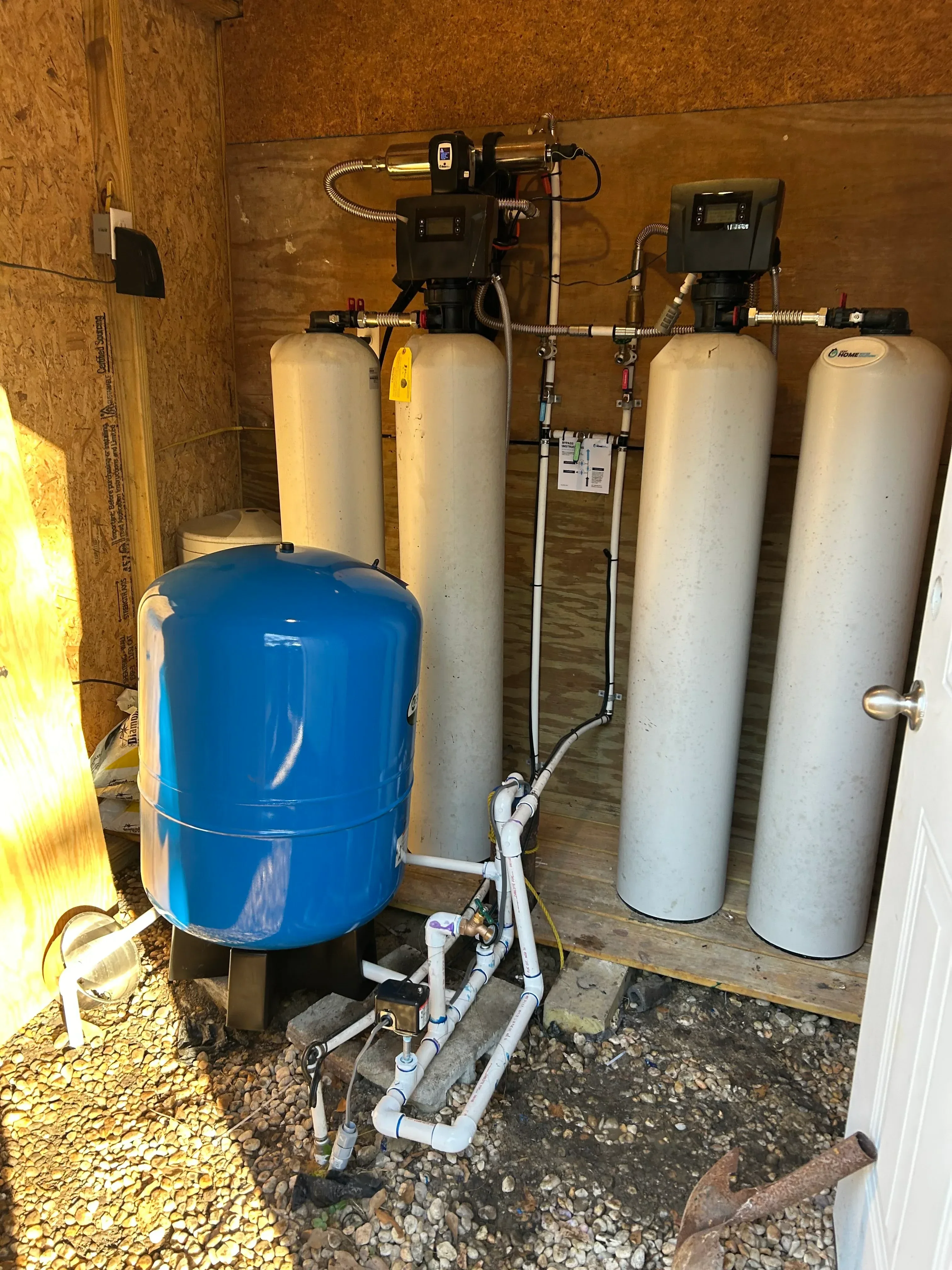 Dual carbon filter water system with blue pressure tank and brass valve manifold