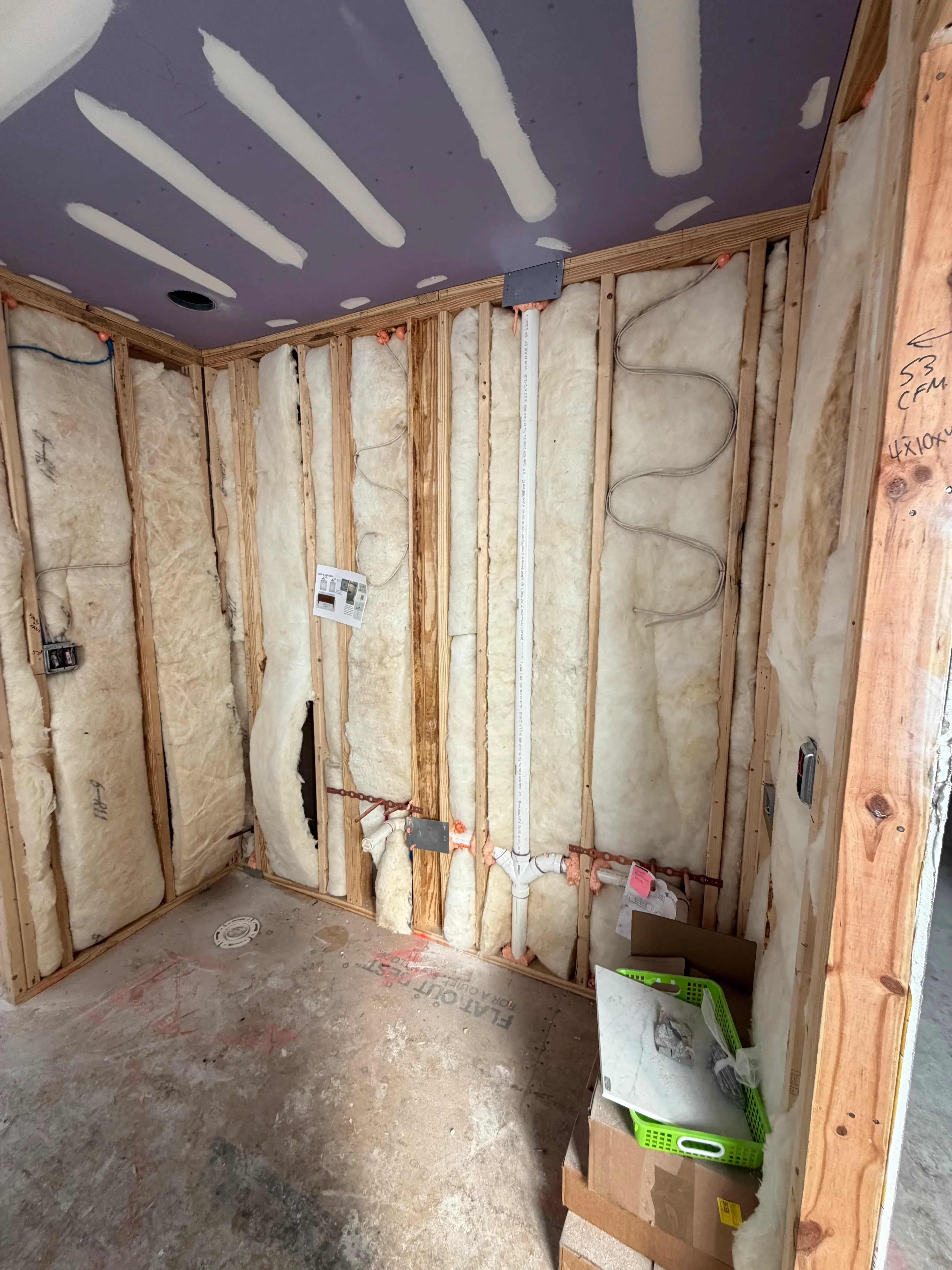 PEX radiant floor heating loops installed between wooden joists with insulation and manifold connections