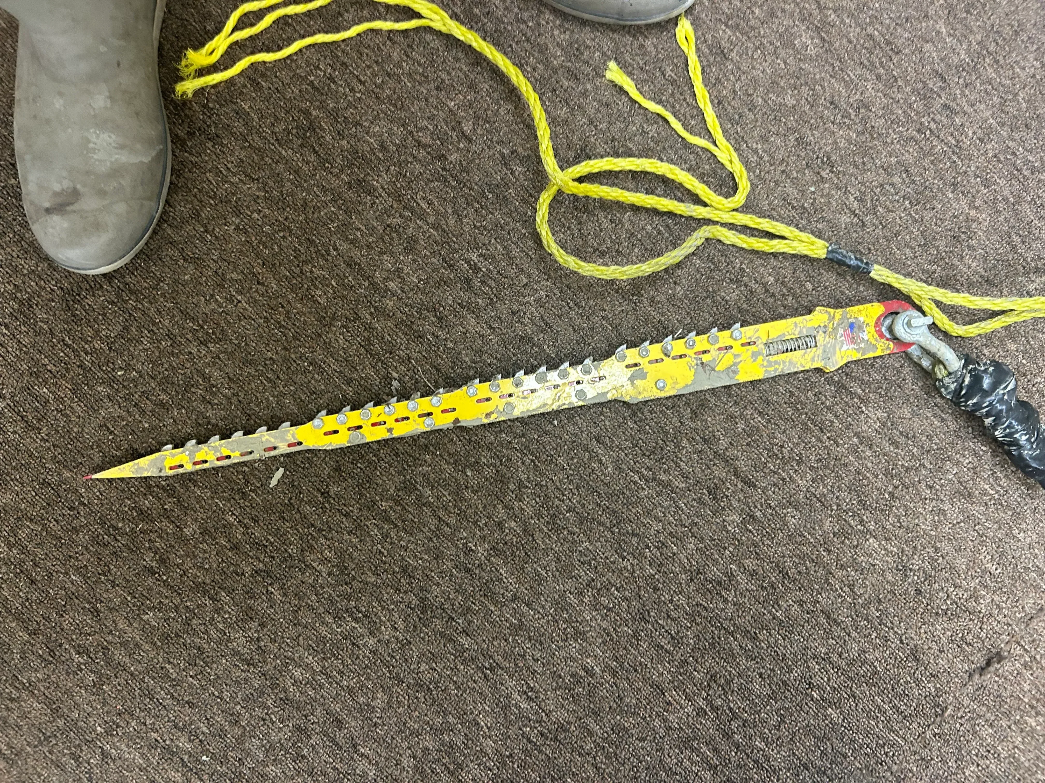 Yellow sewer camera push-rod with cable on concrete surface for underground pipe inspection