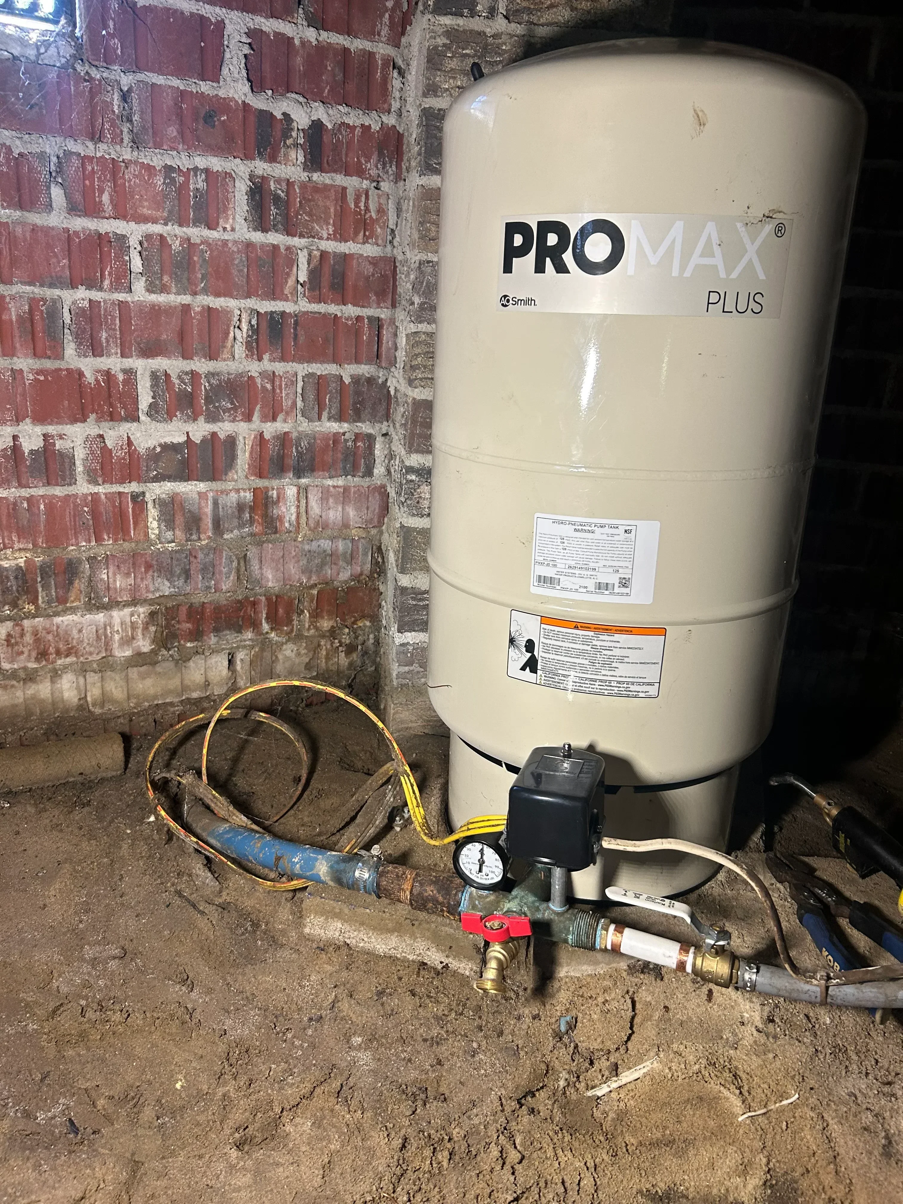 Pro Max Plus water heater tank with pressure gauge, relief valve, and copper piping connections