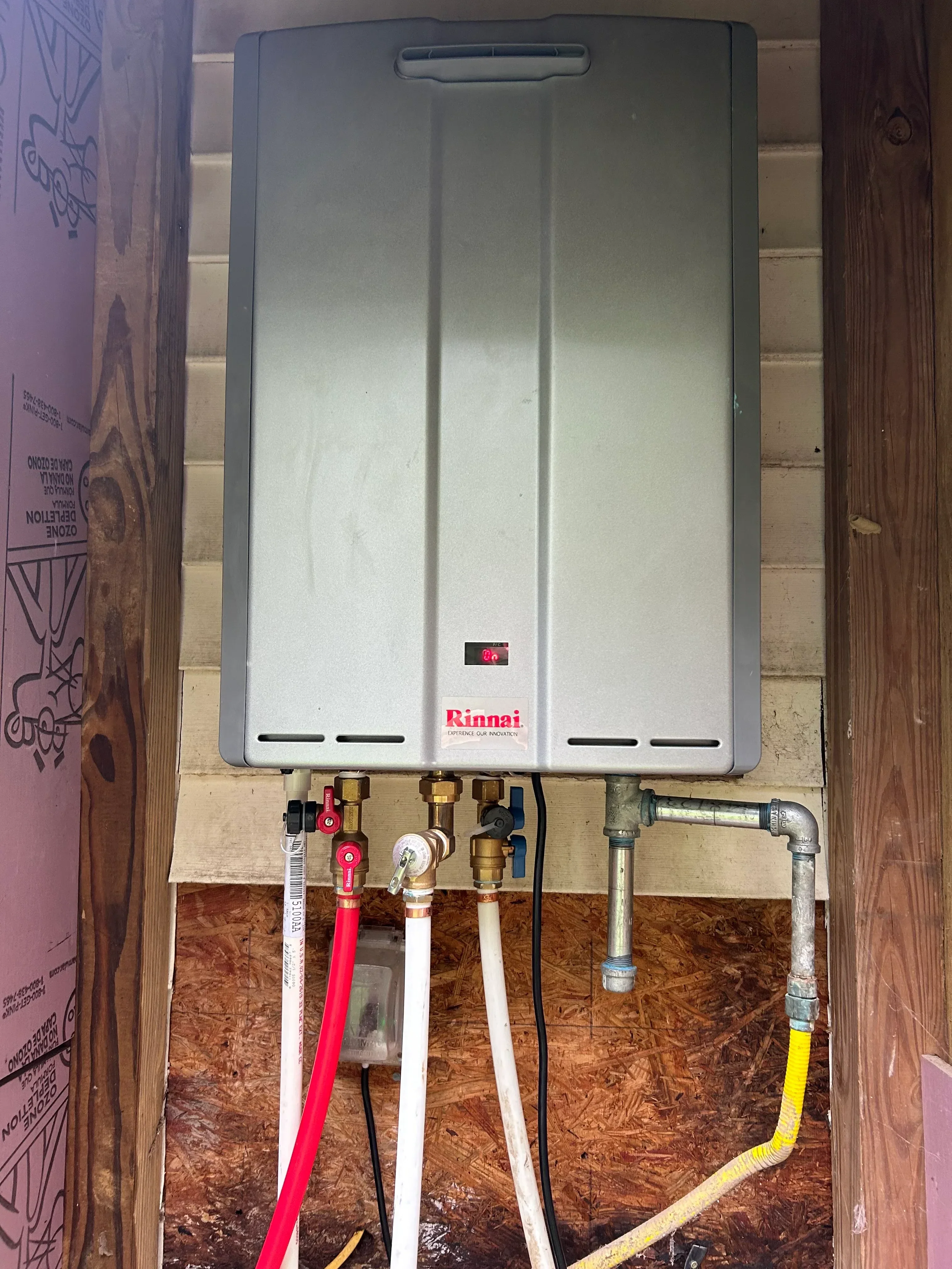 Rinnai tankless water heater with copper piping, brass valves, and gas line installation
