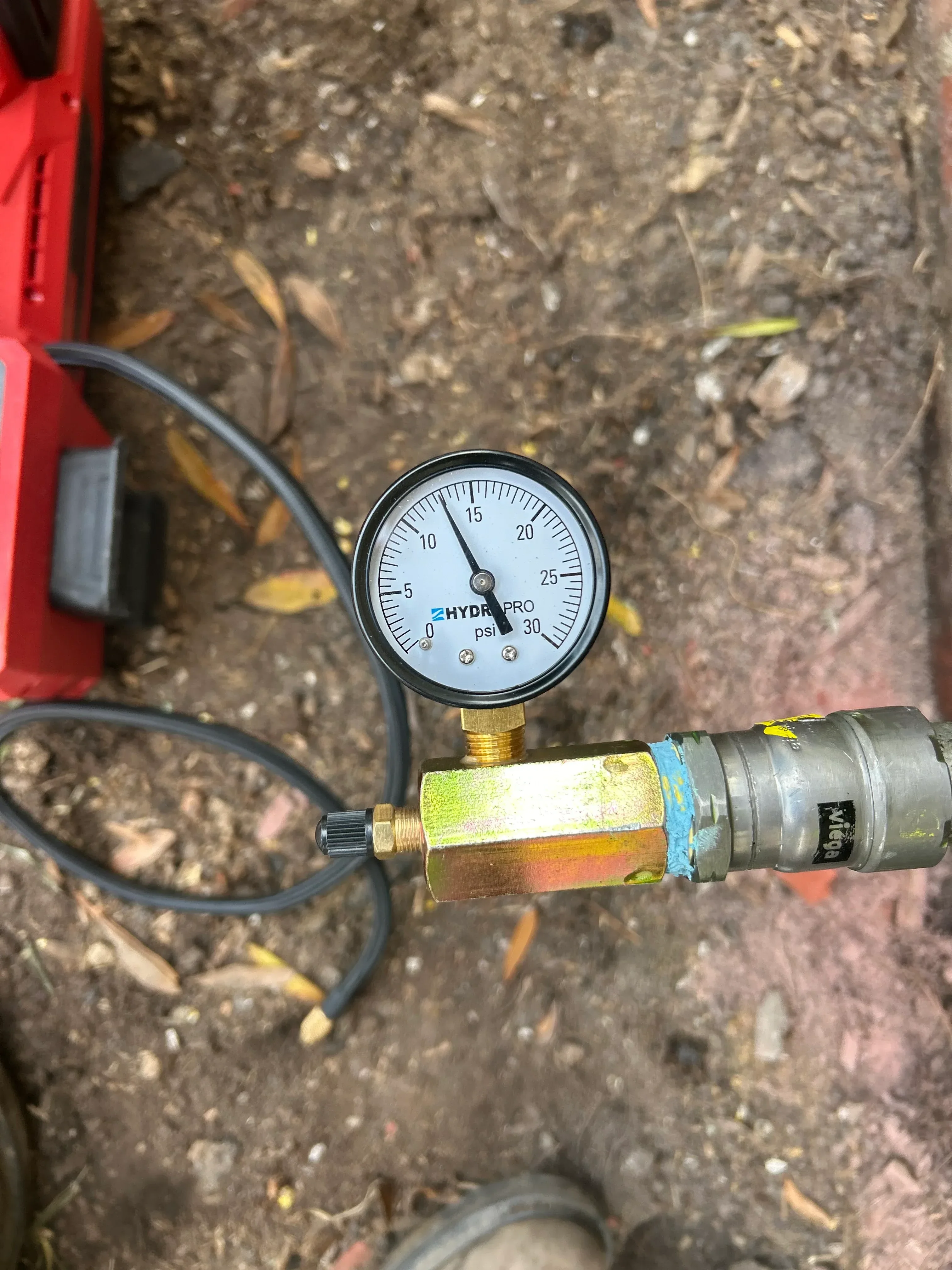 Pressure gauge with brass fittings and regulator valve on plumbing system