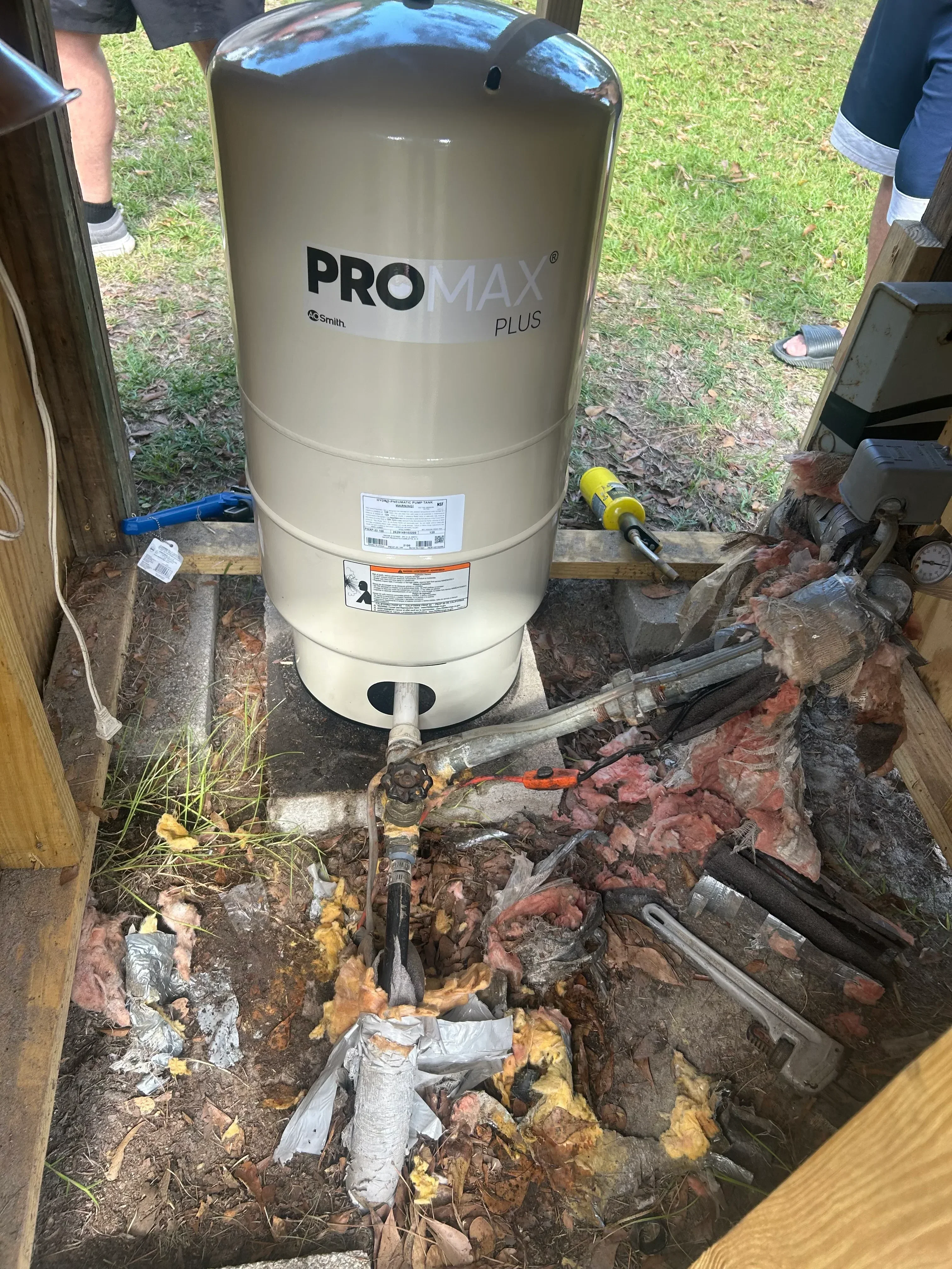 New PRO MAX Plus water heater tank installed in outdoor utility space with connected plumbing