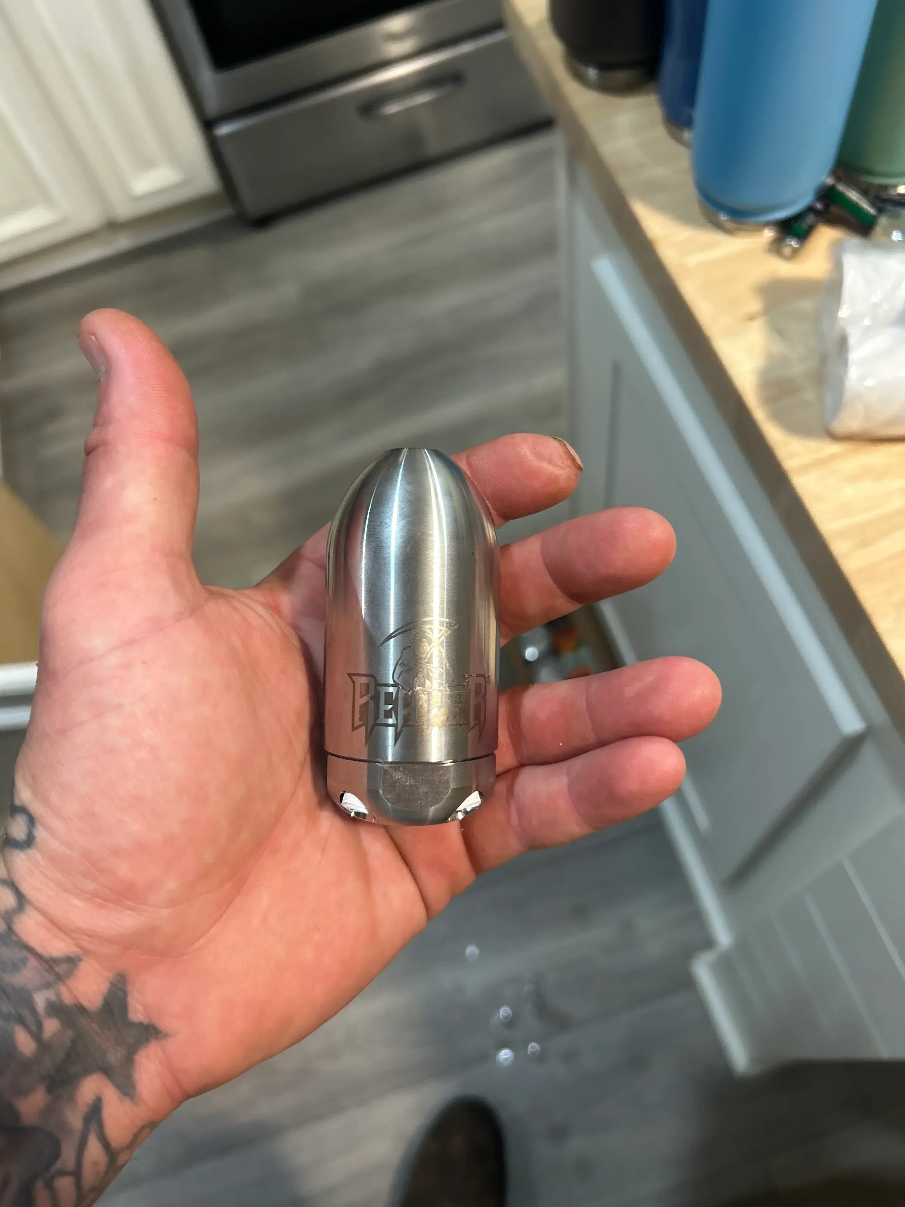 Polished chrome faucet aerator held in hand, showing finished plumbing fixture