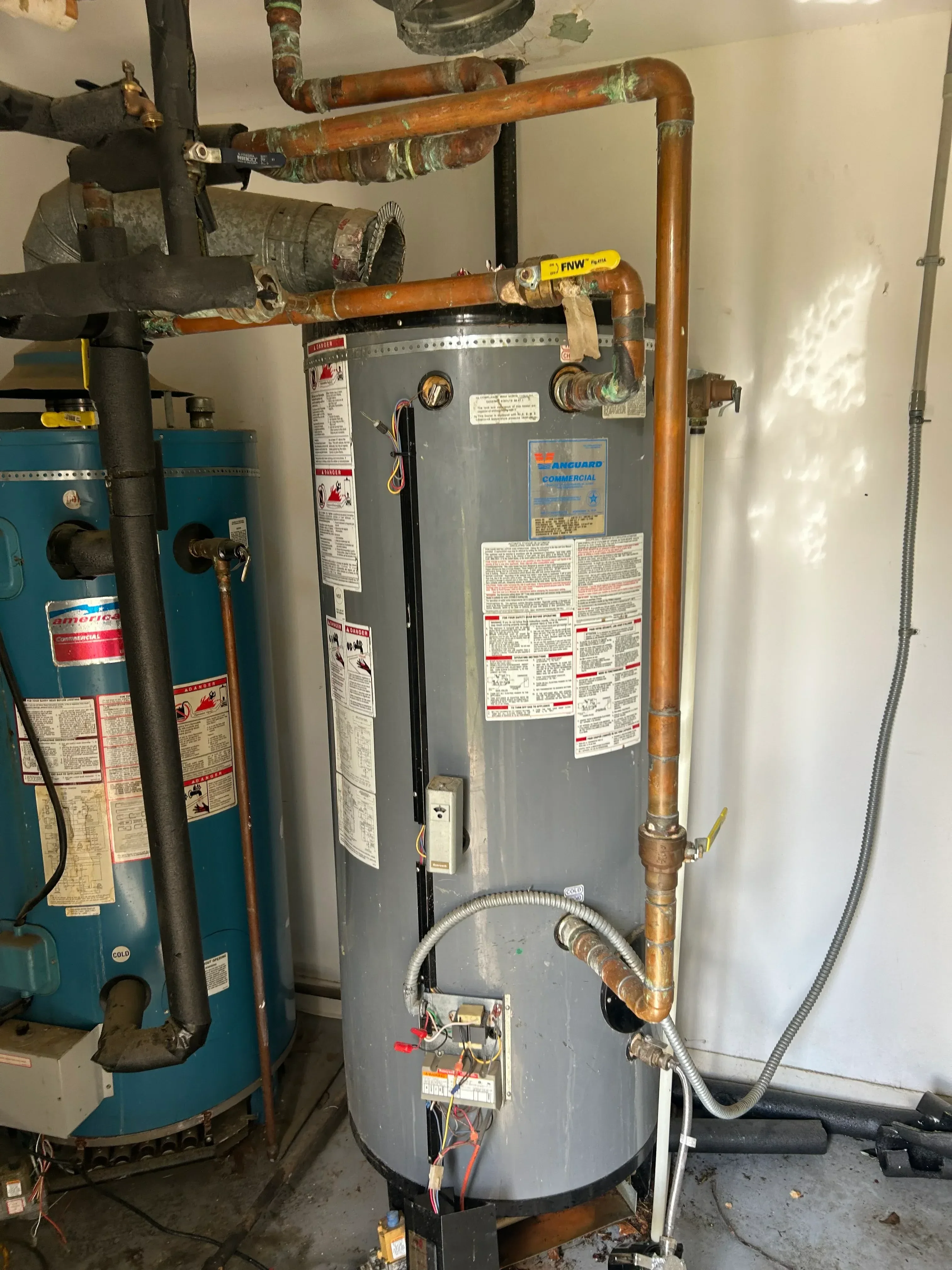 New water heater with copper piping, flexible connectors, and electrical wiring installation